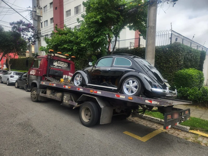 Guincho Sarzi transportando um carro antigo preto inteiro sobre a plataforma